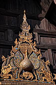 Chiang Mai - The Wat Phan Tao temple, detail of the entrance of the Wihan with the image of a peacock standing over a sleeping dog. 